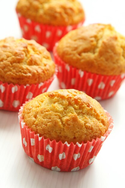 Muffins in red cups on white background