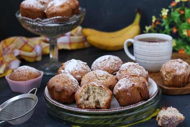 I muffin con le banane si trovano su piatti su uno sfondo scuro