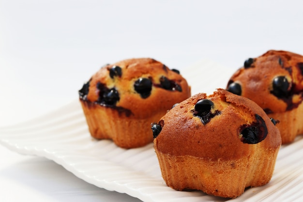 Muffins with black currant on a white background, horizontal photo