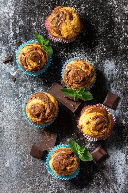 Muffin con cioccolato e menta sullo sfondo di ardesia scura vista dall'alto fondo piatto disteso