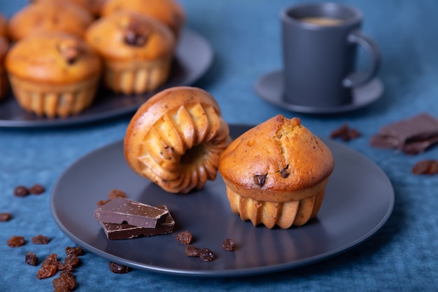 Muffins with chocolate and raisins. Homemade baking. a plate with muffins and a cup of coffee.