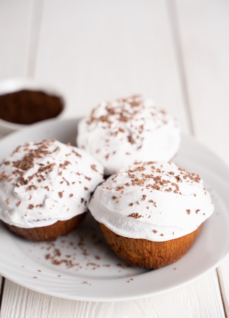 Muffins with white cream and chocolate sprinkles