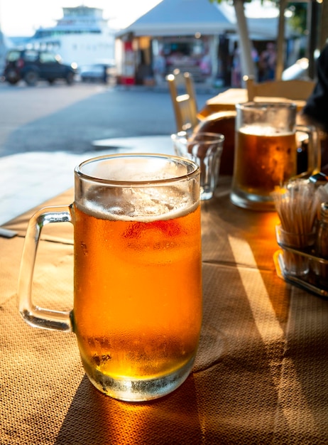 그리스의 한 리조트 선술집에서 일몰에서 태양 아래 맥주 한 잔