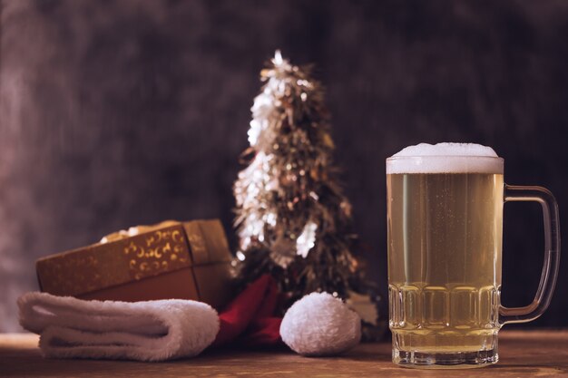 Tazza di birra con decorazioni natalizie sul tavolo di legno.