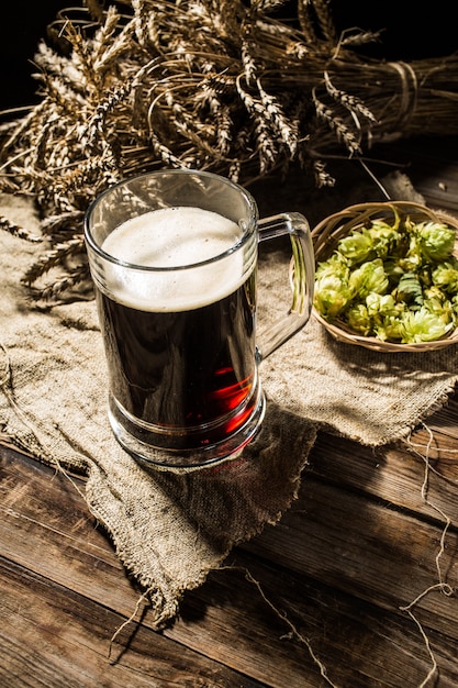 Фото Кружка пива с пшеницей и хмелем на льняной ткани