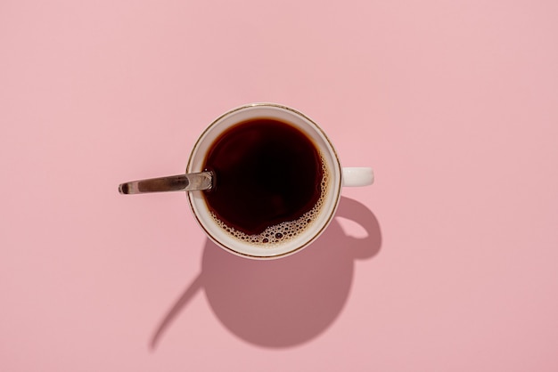 Кружка черного кофе на розовом