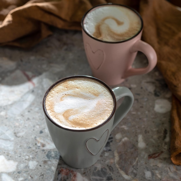 ベージュのカプチーノ コーヒーのマグカップと強い光の中で強い影