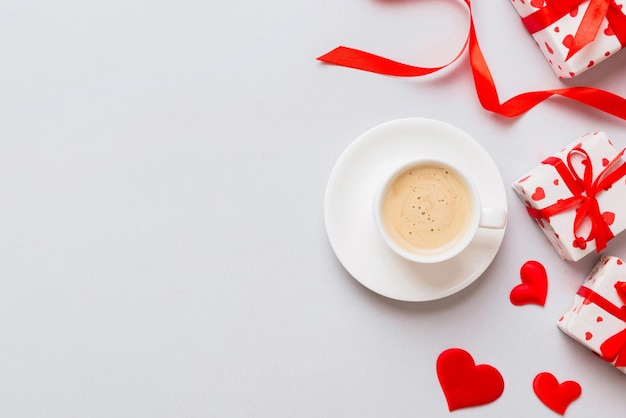 Mug coffee and gift box on colored background Flat lay composition Holiday concept