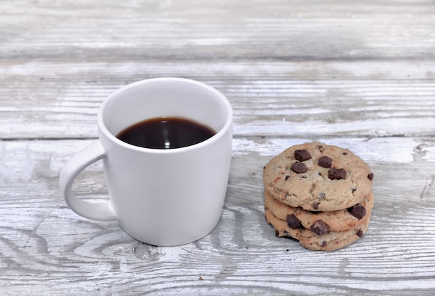 Mug of coffee with cookies on a white table