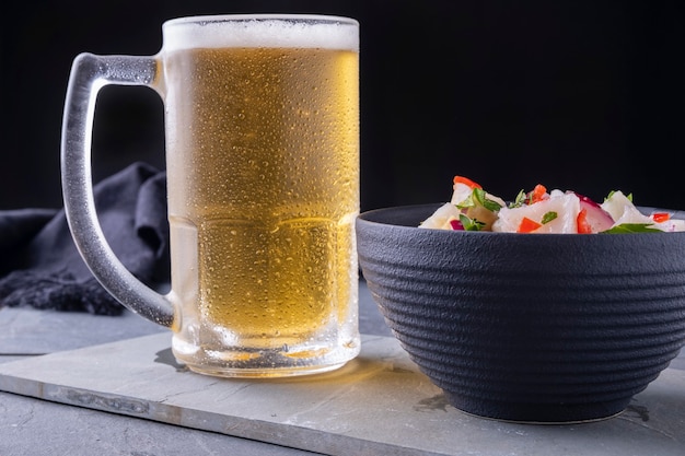 A mug of cold beer and a bowl of ceviche.