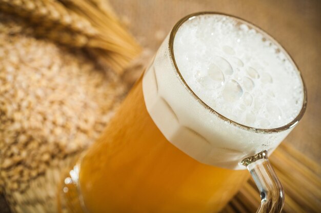 Mug of cold beer on wooden table