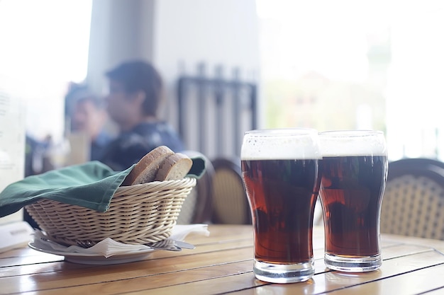 mug of dark beer in the interior of  pub / pint of beer with foam on a served table in  beer restaurant in Czech Republic