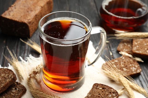 Mug of delicious kvass spikes and bread on table