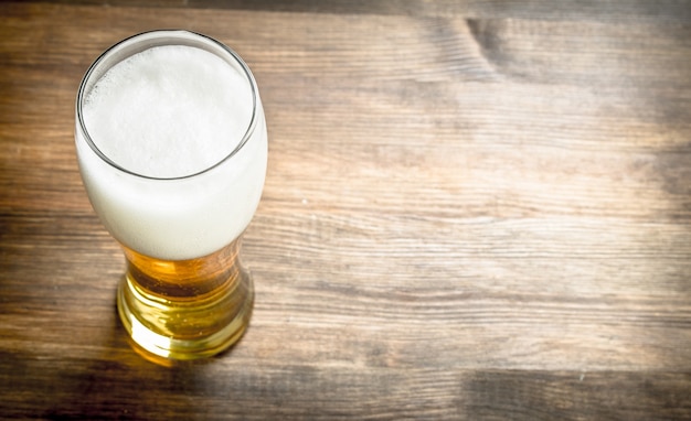 Photo mug of fresh beer. on a wooden table.