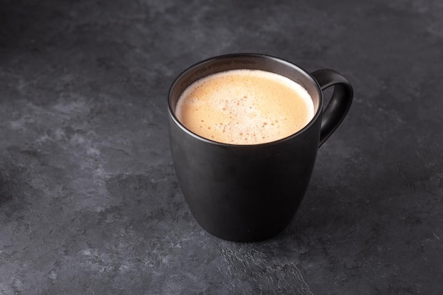 Foto tazza di caffè fresco su sfondo di pietra scura copia spazio per il tuo testo