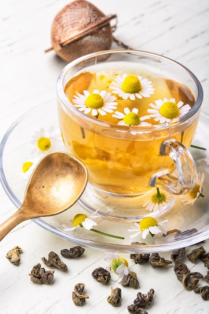 Mug of herb tea with chamomile flowers