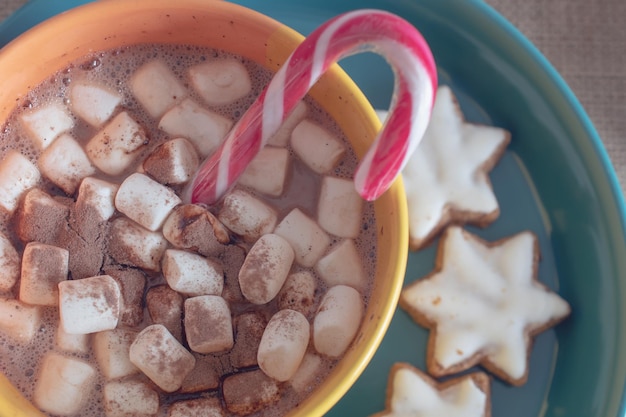 チョコレートとシナモンの背景にマシュマロとホットチョコレートのマグカップ。居心地の良いクリスマスの家の休日