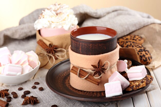 Mug of hot drink decorated in felt on wooden table