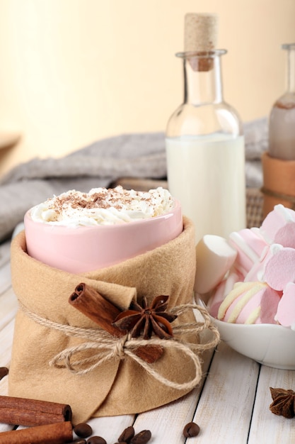 Mug of hot drink decorated in felt on wooden table