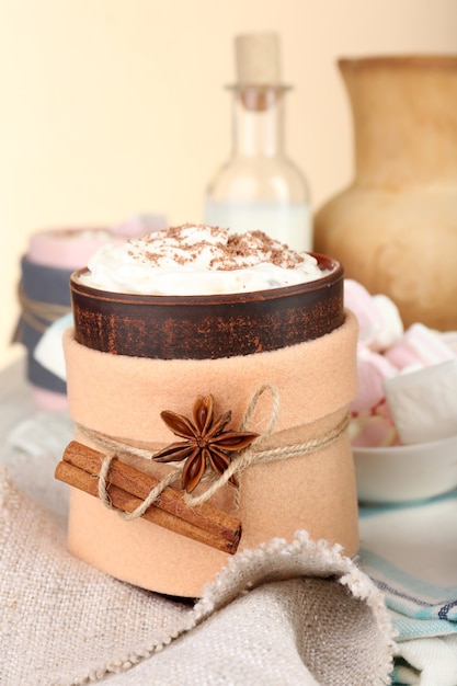 Mug of hot drink decorated in felt on wooden table