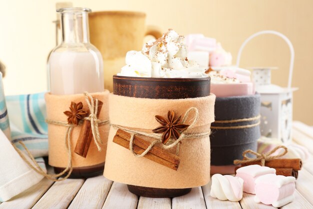 Mug of hot drink decorated in felt on wooden table