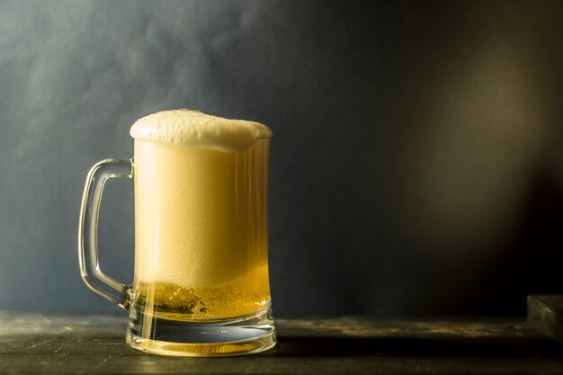 A mug of light beer on a dark background