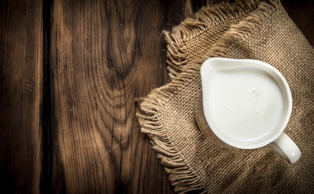 Mug of milk. On a wooden table.