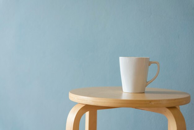 Mug on stool against blue background