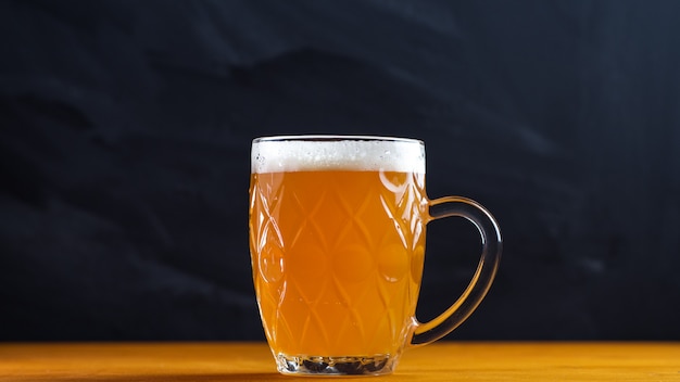 A mug of wheat beer on a wooden table in a pub