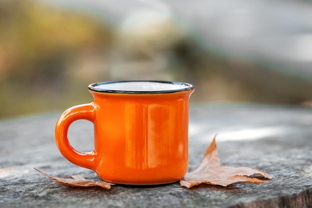 Mug with autumn leaves. Autumn background.