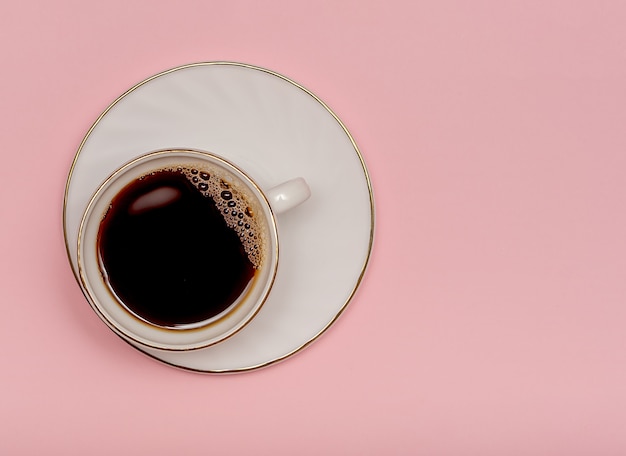 Mug with black coffee on a pink