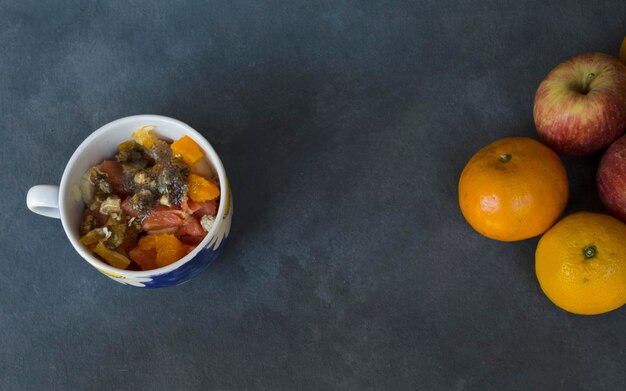 Photo mug with plain fruit salad on the side with room to fill healthy salad with tropical fruits and healthy seeds