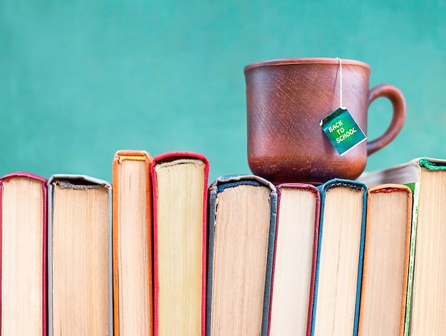 a mug with a tea bag stands on the books closeup