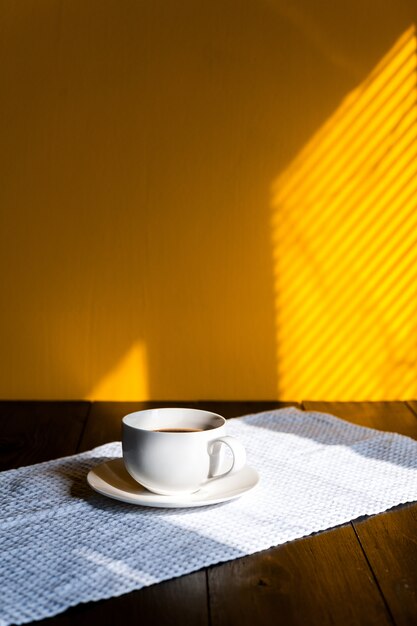 Mug on a wooden table in the morning sun