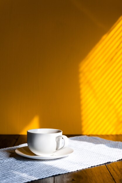 Mug on a wooden table in the morning sun