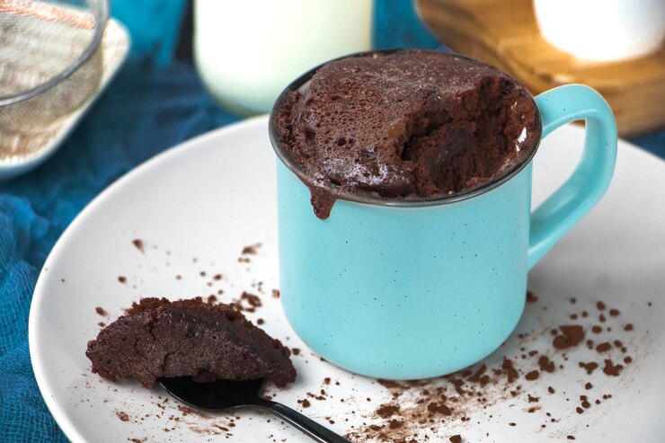 mugcake는 마이크로 웨이브에 넣은 집에서 만든 cupcake는 컵에 접시에 있습니다