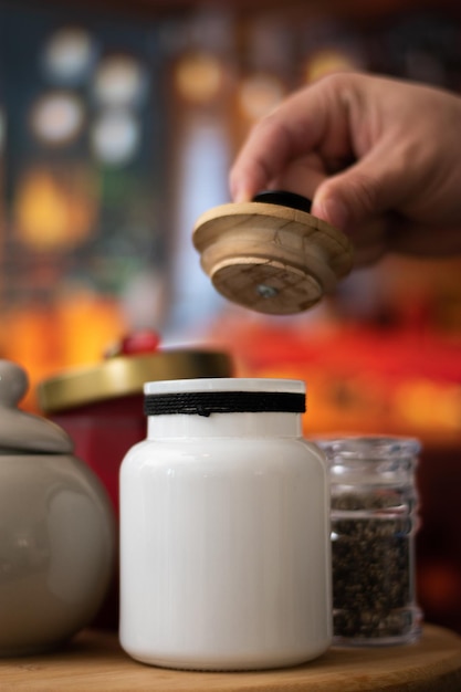 Mugs of sugar while a hand open a containers style vintage over a table in night restaurant