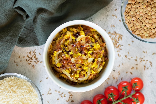 Mujadara lentils and rice pilaf with fried onions on light background
