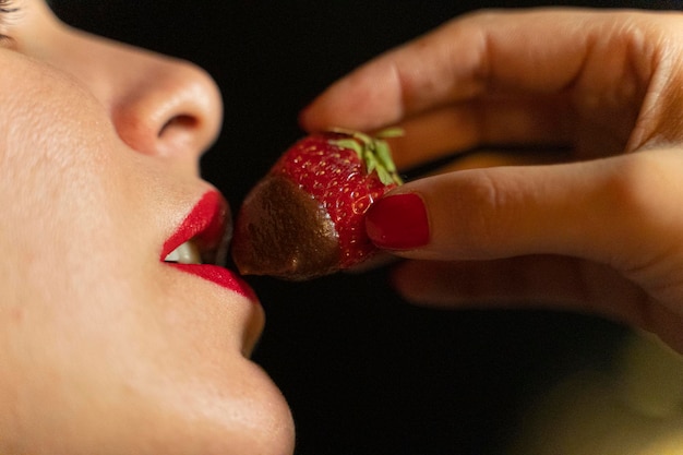 Photo mujer comiendo fresa con chocolate