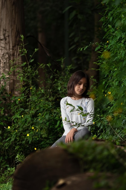 Mujer sentada en bosque encantado