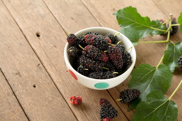 Mulberry is healthy fruit for make juice put on wooden desk background.