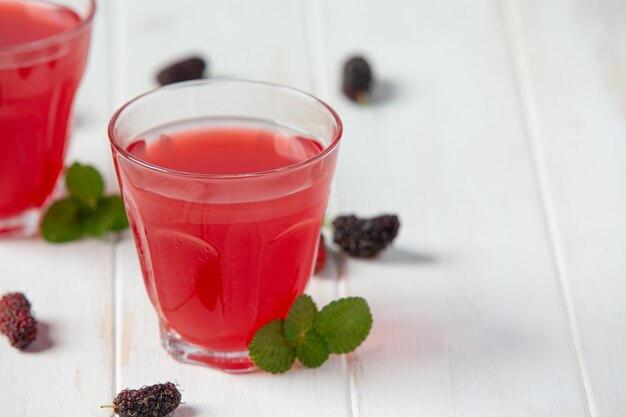 Mulberry juice on white wooden surface