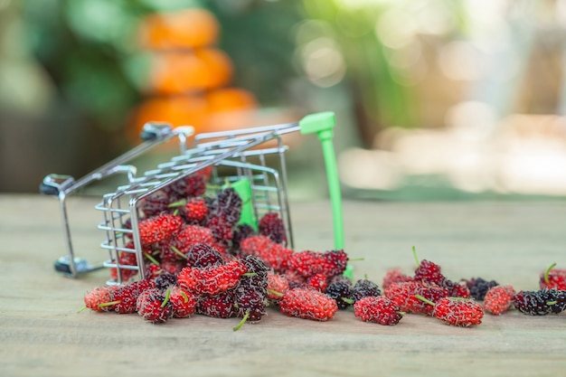 Mulberry in shopping cart on wood 