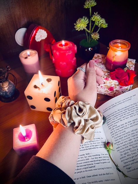 Foto composizione di scrunchie di seta con candele di libro fiori in mano modello di amplificatore