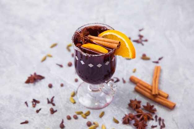 Mulled hot wine with spices on table, traditional christmas drink. Wine, cinnamon, orange