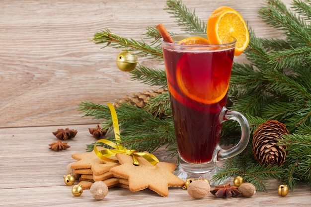 Mulled red wine with  christmas evergreen fir tree  on wooden background