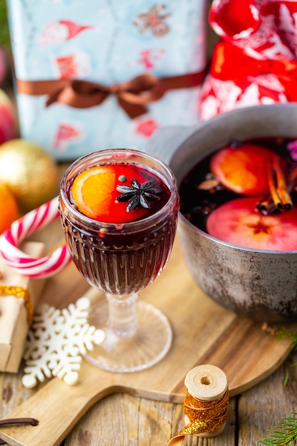 Vin brulè in un bellissimo bicchiere accanto alla casseruola. bevanda calda in un bicchiere. concetto di natale. serata in famiglia con una bevanda calda.