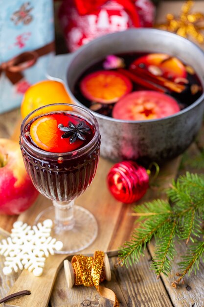 Vin brulè in un bellissimo bicchiere accanto alla casseruola. bevanda calda in un bicchiere. concetto di natale. serata in famiglia con una bevanda calda.