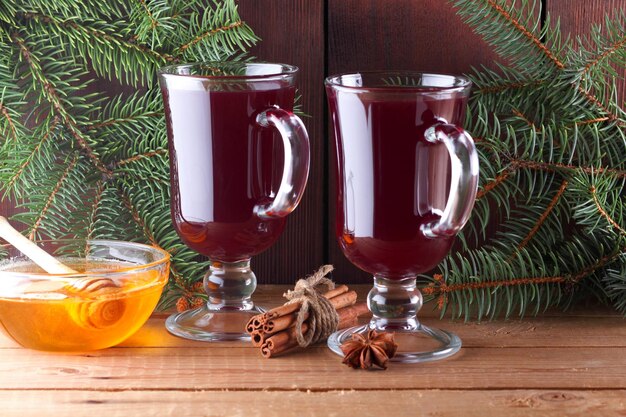 Photo mulled wine and christmas tree branches on wooden boards christmas mulled wine