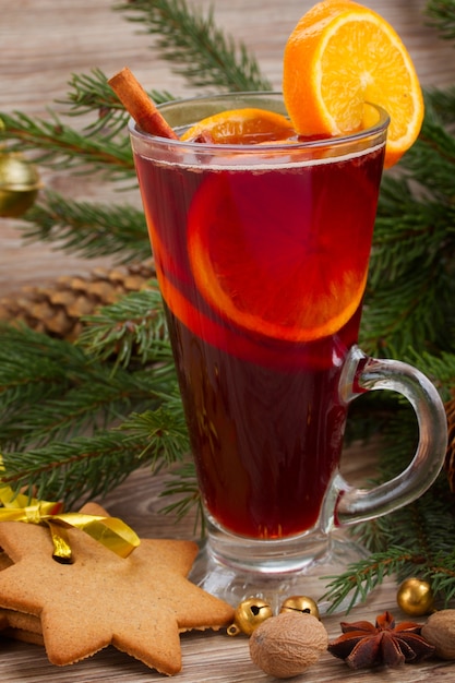 Mulled wine and gingerbread cookies on wooden table